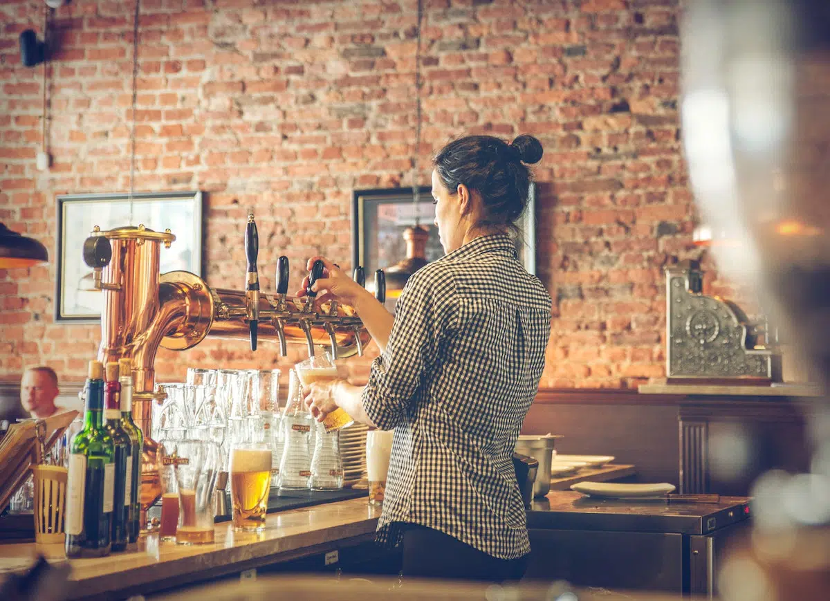 Bartender pouring a beer at a dram shop