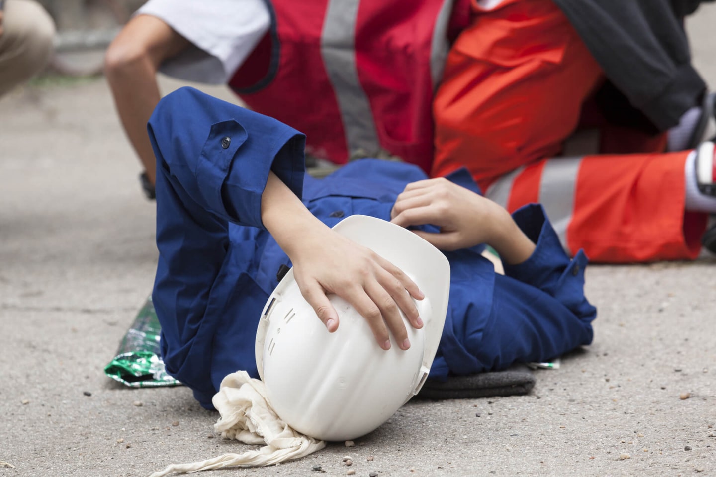 Construction Worker Laying on the Ground While a Medic is Attending at Them