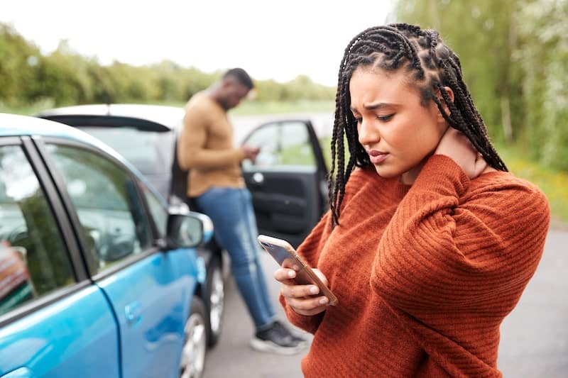 Two People In A Car Accident Checking Their Phones