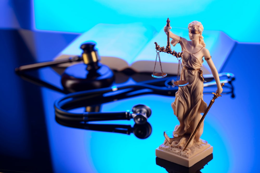 Lady Justice Statue with Gavel and Stethoscope on the Background